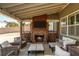 Cozy outdoor patio with a stone fireplace, TV, and comfortable seating for relaxation at 5390 Chestnut Dr, Cumming, GA 30040