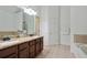 Bathroom with double vanity sinks, granite counters, tile floors, and a soaking tub at 1519 Dolcetto Nw Trce # 1, Kennesaw, GA 30152