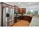 Beautiful kitchen boasts granite countertops, wood cabinets, and stainless steel appliances with open view to living area at 1519 Dolcetto Nw Trce # 1, Kennesaw, GA 30152