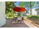 Outdoor patio with brickwork, dining set with umbrella, and backyard view at 2693 Greentree Se Dr, Marietta, GA 30067