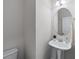 Elegant powder room with pedestal sink, oval mirror, and modern fixtures providing a convenient space for guests at 2732 Pierce Brennen Ct, Lawrenceville, GA 30043