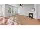Bright living room with a cozy fireplace, ceiling fan, and lots of windows overlooking the backyard at 2732 Pierce Brennen Ct, Lawrenceville, GA 30043