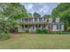 Charming two-story home with a welcoming front porch, American flag and landscaped yard at 293 Country Lake Dr, Mcdonough, GA 30252