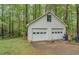 Two-car white garage with trees, grass and a concrete driveway at 293 Country Lake Dr, Mcdonough, GA 30252