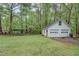 Two-car white garage with lawn, trees, and a concrete driveway at 293 Country Lake Dr, Mcdonough, GA 30252