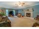 Spacious living room featuring a fireplace, ceiling fan, and large windows at 293 Country Lake Dr, Mcdonough, GA 30252
