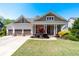 Charming home with a welcoming front porch, three-car garage, and beautifully landscaped front yard at 3137 Perimeter Cir, Buford, GA 30519