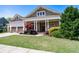 Inviting home with a covered front porch, a manicured lawn, and a lovely landscaped garden at 3137 Perimeter Cir, Buford, GA 30519