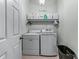 Well-equipped laundry room with washer, dryer, and storage shelves at 3137 Perimeter Cir, Buford, GA 30519