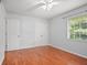Bright bedroom features hardwood floors, a ceiling fan, and a large window at 6940 Roswell Rd # 24E, Sandy Springs, GA 30328
