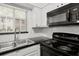 Close up of a modern kitchen with black appliances, and subway tile back splash at 6940 Roswell Rd # 24E, Sandy Springs, GA 30328
