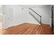Open-concept living room with hardwood floors and stairs with a white banister at 6940 Roswell Rd # 24E, Sandy Springs, GA 30328