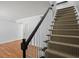 Carpeted staircase with dark wood railing and white spindles in a home with wood floors at 6940 Roswell Rd # 24E, Sandy Springs, GA 30328