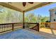 Cozy covered back porch featuring wood railings, outdoor lights, ceiling fan and a blue rug at 5320 Northview Lk, Cumming, GA 30040