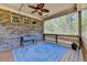 Inviting back porch with a ceiling fan, outdoor lighting, brick wall and blue outdoor rug at 5320 Northview Lk, Cumming, GA 30040