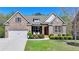 Charming brick home featuring a well-manicured lawn and an attached two-car garage at 5320 Northview Lk, Cumming, GA 30040