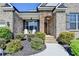 Inviting front porch with stone details, complemented by well-maintained landscaping at 5320 Northview Lk, Cumming, GA 30040