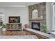Living room with a stone fireplace, hearth, flat screen TV, hardwood floors, and plants at 5320 Northview Lk, Cumming, GA 30040