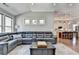 Living room featuring a large leather sofa, multiple windows, and an open view into the kitchen at 5320 Northview Lk, Cumming, GA 30040