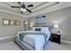 Inviting main bedroom with tray ceilings, a ceiling fan, large windows, and a view of the backyard at 5320 Northview Lk, Cumming, GA 30040