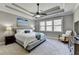 Relaxing main bedroom featuring a tray ceiling, ceiling fan, and large windows for ample natural light at 5320 Northview Lk, Cumming, GA 30040