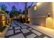 Backyard featuring a stone paver patio, detached garage, and wooden fence with ambient lighting at dusk at 1010 Eden Se Ave, Atlanta, GA 30316