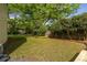A large backyard with a mix of lawn and trees, enclosed by a wooden fence, perfect for outdoor activities at 1010 Eden Se Ave, Atlanta, GA 30316