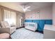 Bright Bedroom featuring blue trim, a white crib, and a glider at 1010 Eden Se Ave, Atlanta, GA 30316