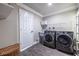 Well-lit laundry room features front load washer and dryer, storage and modern grey flooring at 1010 Eden Se Ave, Atlanta, GA 30316