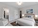 Carpeted bedroom has a framed ocean art piece and is furnished with a queen bed and an armchair at 1911 Commons Cir, Brookhaven, GA 30341