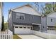 Charming two-story home with gray siding, white trim, a front garage, and a welcoming white picket fence at 1911 Commons Cir, Brookhaven, GA 30341