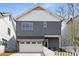 Charming two-story home with gray siding, white trim, a front garage, and a welcoming white picket fence at 1911 Commons Cir, Brookhaven, GA 30341