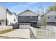 Charming two-story home with gray siding, white trim, a front garage, and a welcoming white picket fence at 1911 Commons Cir, Brookhaven, GA 30341