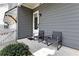 A small front porch has gray siding and is furnished with a bistro set at 1911 Commons Cir, Brookhaven, GA 30341