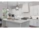 Bright kitchen with white cabinets, quartz countertops, stainless steel appliances, and modern light fixtures at 1911 Commons Cir, Brookhaven, GA 30341