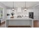 Bright kitchen featuring white cabinets, quartz countertops, stainless steel appliances, and modern lighting at 1911 Commons Cir, Brookhaven, GA 30341