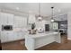 Elegant kitchen with white cabinets, a center island, and modern lighting fixtures at 1911 Commons Cir, Brookhaven, GA 30341