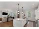 Open-concept kitchen with a large island that flows into the living room with a fireplace at 1911 Commons Cir, Brookhaven, GA 30341