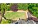Aerial view of backyard featuring stone patio, a wooden hot tub, well-kept lawn, and mature trees at 2141 Abby Ne Ln, Atlanta, GA 30345