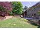 Serene backyard view showcasing a wooden hot tub, stone patio, manicured lawn and lush landscaping at 2141 Abby Ne Ln, Atlanta, GA 30345