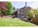 Expansive backyard with a wooden hot tub, stone patio, and a manicured lawn at 2141 Abby Ne Ln, Atlanta, GA 30345