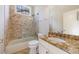 Well-lit bathroom features a granite countertop, a glass-enclosed shower, and neutral tile at 2141 Abby Ne Ln, Atlanta, GA 30345