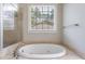 Bathroom featuring soaking tub with stone accents and separate shower with glass door at 2141 Abby Ne Ln, Atlanta, GA 30345