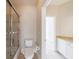 Bathroom featuring a tiled shower with glass doors, toilet, vanity, and bright lighting at 2141 Abby Ne Ln, Atlanta, GA 30345