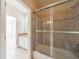 View of a bathroom showcasing a tiled shower with glass doors and white cabinets with a granite countertop at 2141 Abby Ne Ln, Atlanta, GA 30345