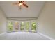 Bedroom featuring a vaulted ceiling, ceiling fan, carpeted floor, and a bay window overlooking lush landscaping at 2141 Abby Ne Ln, Atlanta, GA 30345