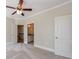 Bedroom featuring a ceiling fan, neutral walls, carpet floors, plus an ensuite bath and access to other rooms at 2141 Abby Ne Ln, Atlanta, GA 30345