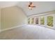 Spacious bedroom with vaulted ceiling, ceiling fan, and a large bay window overlooking the backyard at 2141 Abby Ne Ln, Atlanta, GA 30345