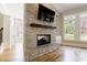 Stylish stone fireplace with a mounted TV, hardwood floors, built-in shelving and natural light from the windows at 2141 Abby Ne Ln, Atlanta, GA 30345