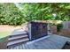 Backyard with hot tub featuring wooden steps and deck, surrounded by green grass and lush trees at 2141 Abby Ne Ln, Atlanta, GA 30345